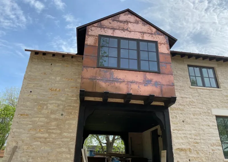 Copper metal panel facade on a stone building for Skylight Installation in Bondurant